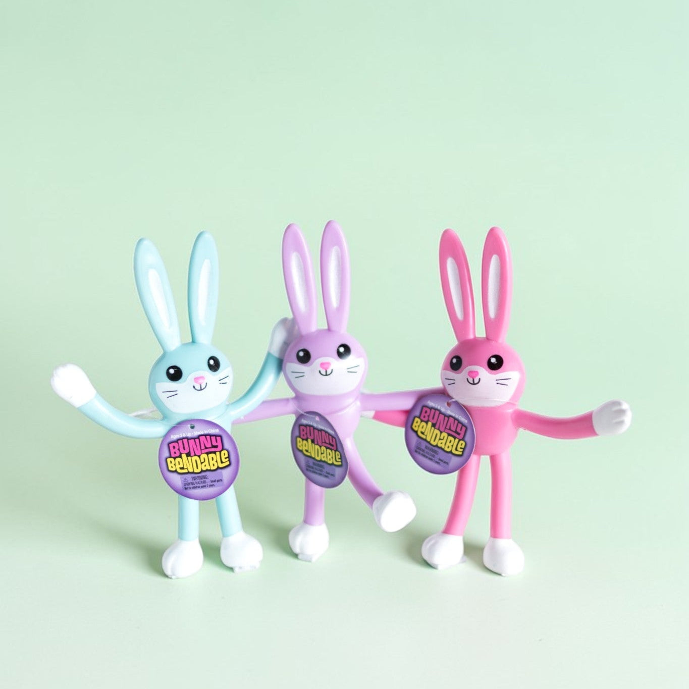 Three colorful bunny figurines with a light green background